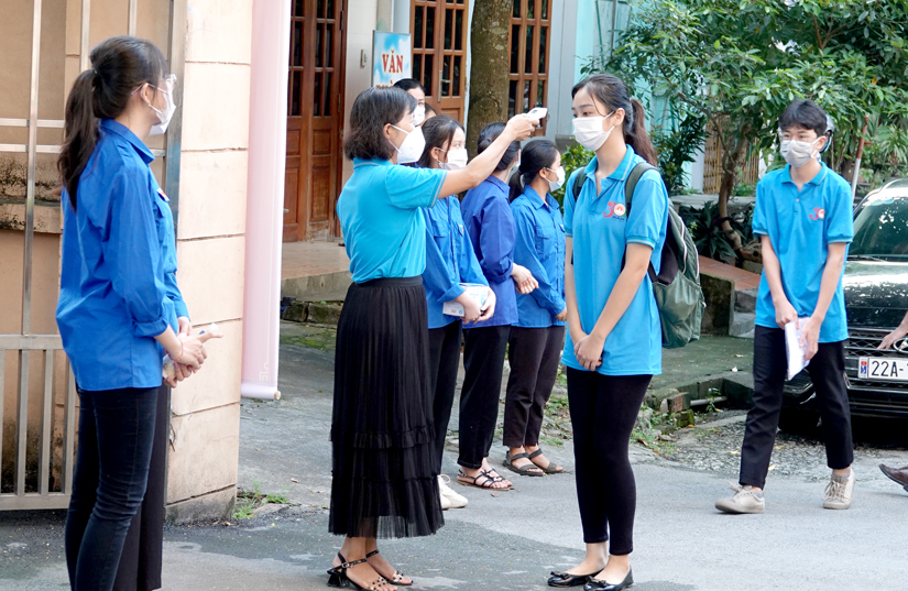 Kiểm tra thân nhiệt thí sinh trước khi vào điểm thi Trường THPT Chuyên Tuyên Quang. Ảnh: Huy Hoàng