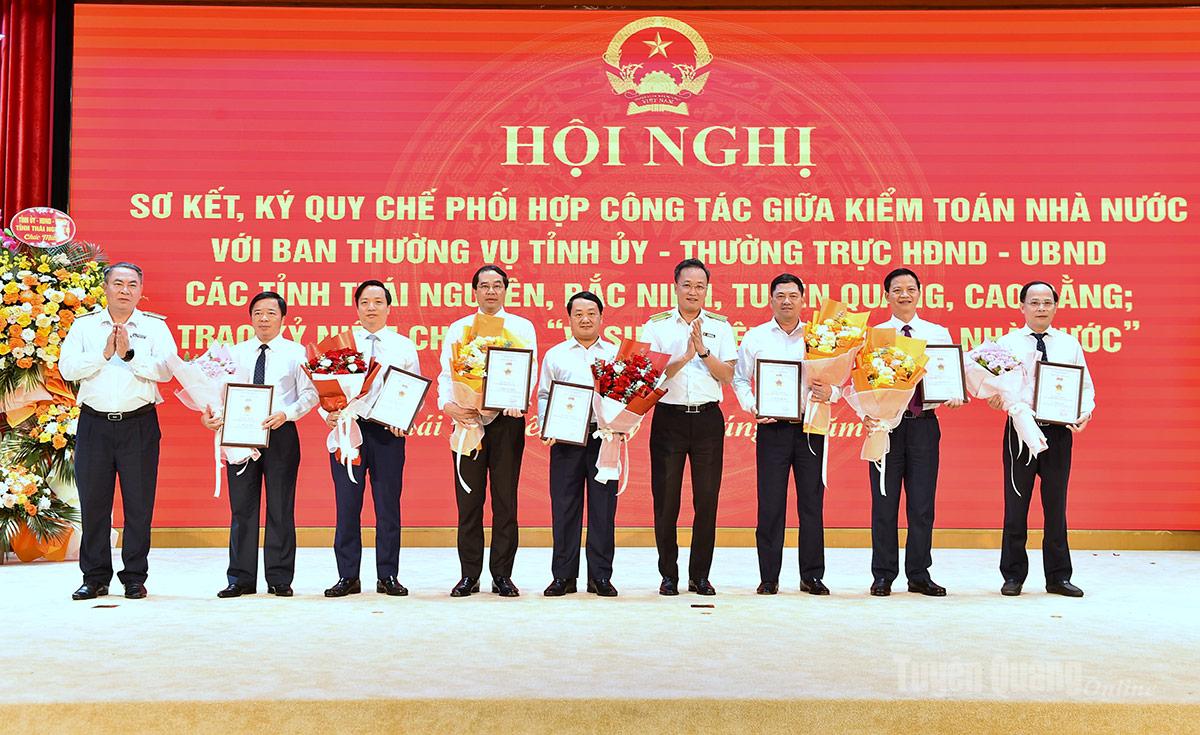 Đồng chí Nguyễn Hữu Nghĩa, Tổng Kiểm toán Nhà nước tra Kỷ niệm chương cho các đại biểu.