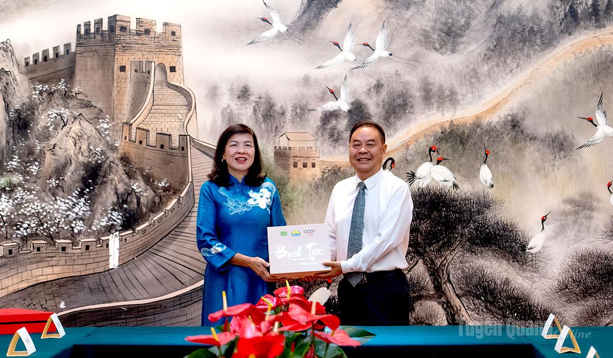 Đồng chí Phạm Thị Minh Xuân, Ủy viên Ban Thường vụ Tỉnh ủy, Phó Chủ tịch Hội đồng nhân dân tỉnh Tuyên Quang tặng quà đồng chí  Vương Nghị, Chủ nhiệm Ban Thường vụ Nhân đại châu Văn Sơn.