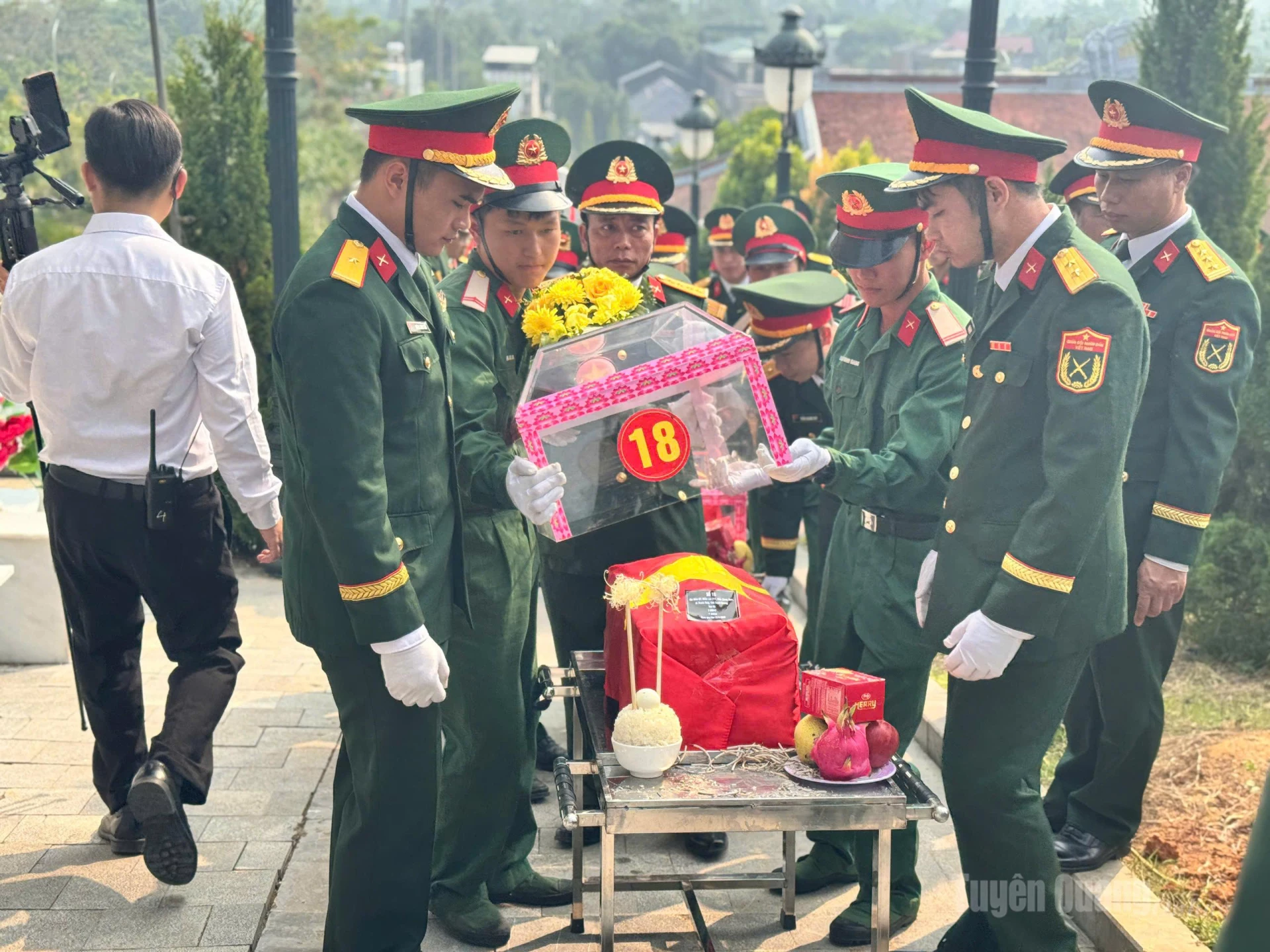 Nghi thức thu lồng kính trước khi hài cốt các liệt sĩ được hạ huyệt. Ảnh: Mai Ánh