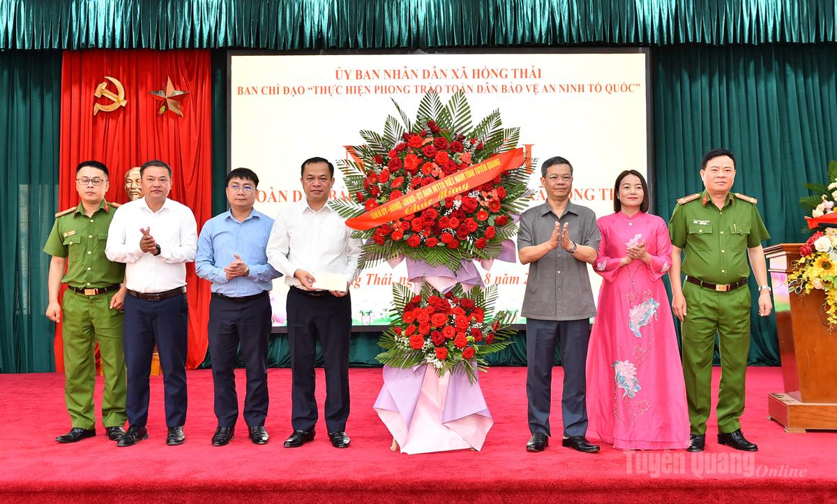 Đồng chí Nguyễn Văn Sơn, Chủ tịch HĐND tỉnh tặng hoa chúc mừng Ngày hội toàn dân bảo vệ an ninh Tổ quốc xã Hồng Thái.