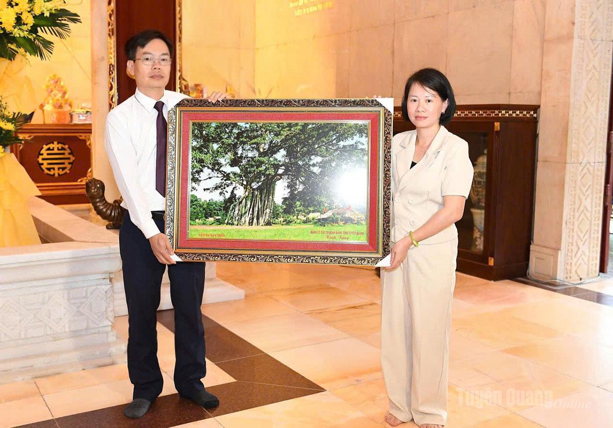 Đồng chí Phó trưởng ban Thường trực Ban Tuyên giáo và Dân vận Tỉnh ủy Nguyễn Lam Sơn tặng bức ảnh Cây đa Tân Trào cho Ban Quản lý Khu Di tích Quốc gia đặc biệt Pác Bó.